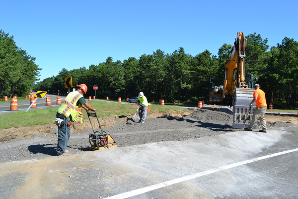 Construction workers from Pratt Brothers Inc. work on the new traffic circle in Flanders on Tuesday morning.