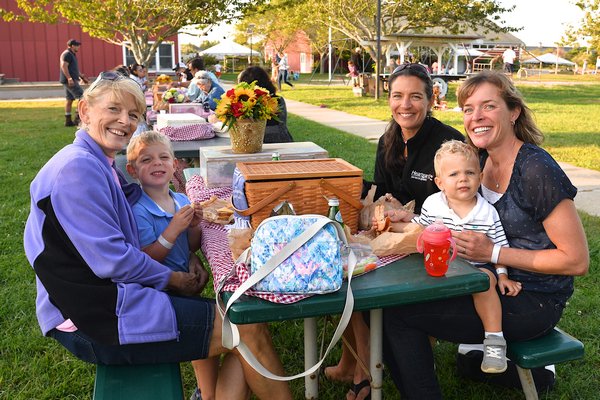 Hayground School in Bridgehampton hosted a benefit picnic on Saturday for Debajo de las Palmas, which helps children and families in the Dominican Republic. Among those attending were, from left, Mickey Caputo, Sidney Payne, Heather Caputo, Sawyer Payne and Jeanette Payne.  KYRIL BROMLEY