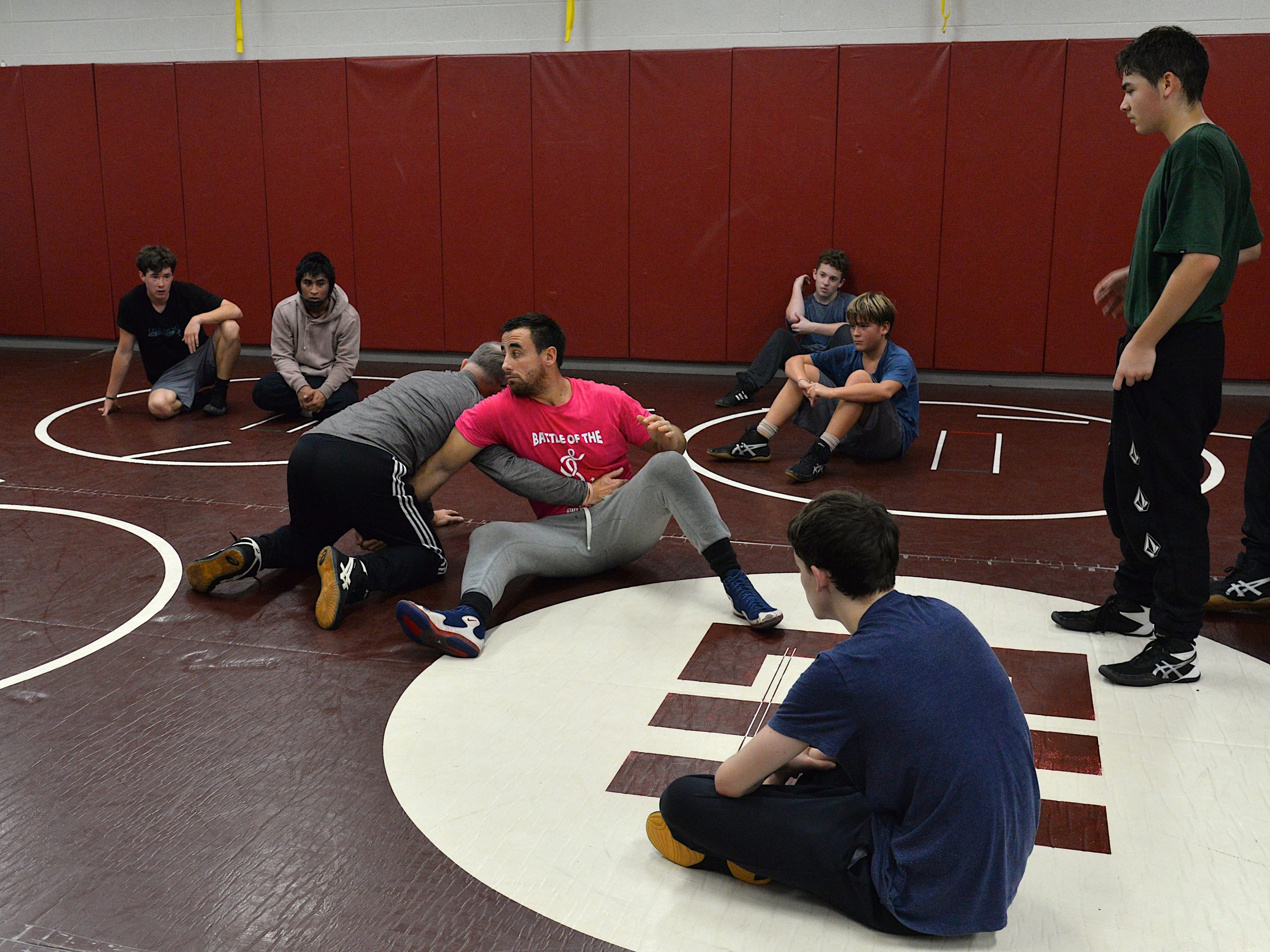 Coaches Ethan Mitchell and Jim Stewart teach their wrestlers during practice.
