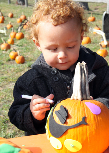 Samuel Meltzer works on a pumpkin decorating craft at the Child Development Center of 