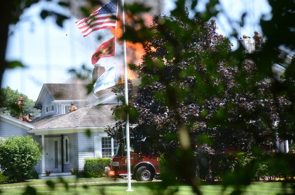 Flames tore through a roof of the home at 104 Halsey Neck Lane on Friday afternoon. GREG WEHNER