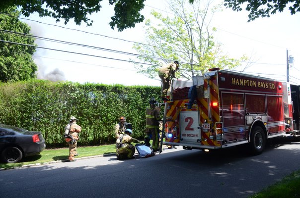 Firefighters worked to put out a fire at 104 Halsey Neck Lane in Southampton Village on Friday. GREG WEHNER