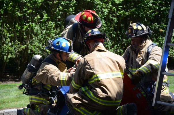 Hampton Bays firefighters get ready to help put out a fire at 104 Halsey Neck Lane in Southampton Village on Friday. GREG WEHNER