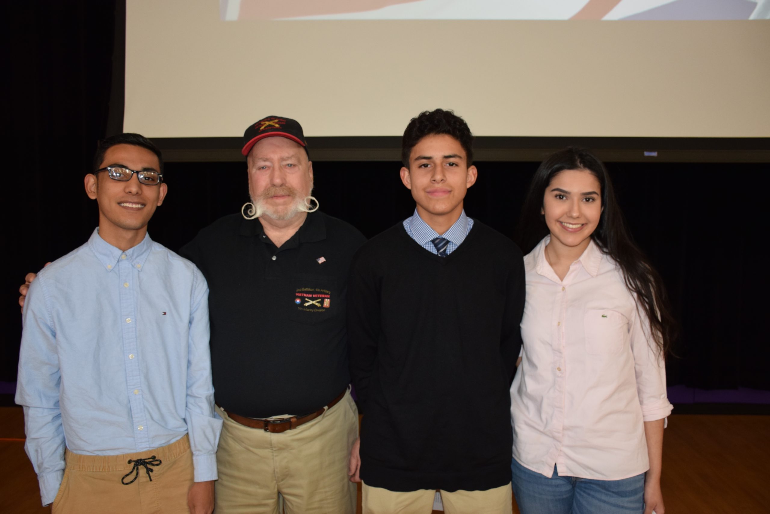 Hampton Bays High School students honored U.S. Navy veteran Dick Crescenzo during a flag ceremony on December 6. Among the students at the ceremony were three students who will be entering the military following graduation. From left, Pedro Robles (U.S. Army), Mr. Crescenzo, Kyle Rodriguez (U.S. Air Force) and Sophia Gonzalez (U.S. Air Force).