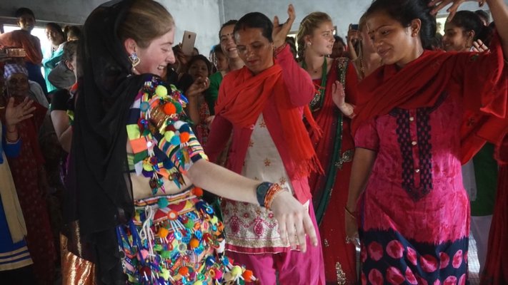 Sophie Flax dancing with some villagers.  COURTESY WILLIAM BARBOUR