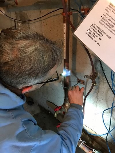 John Siedlarz works on repairing a burst pipe. COURTESY JOHN SIEDLARZ