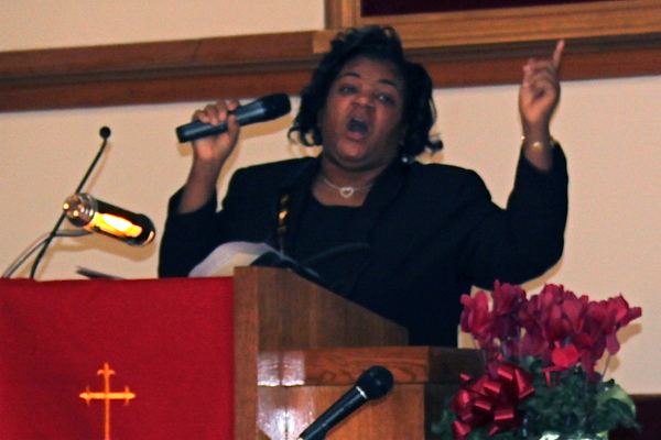 An attendee at the Martin Luther King Jr. celebration stands and claps for the speaker.