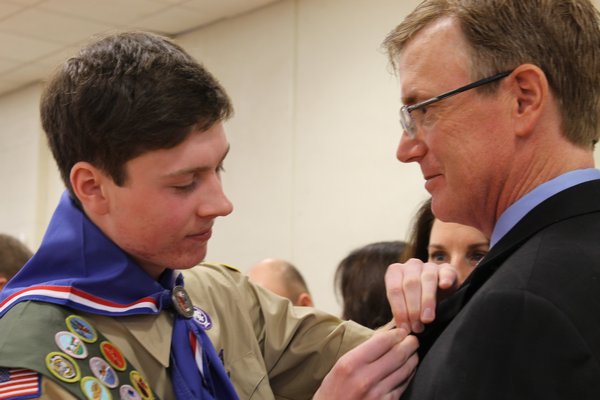 Scoutmaster Allen Schneider helps Colin Cuccia put on his Eagle Scout neckercheif January 11 at the St. Rosalie's Community Center on Montauk Highway in Hampton Bays. KYLE CAMPBELL