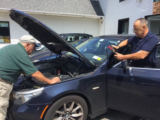 Angelo and John de la Fuente work on fixing a BMW on Tuesday afternoon. ELSIE BOSKAMP