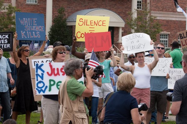 Participants hold signs during a Black