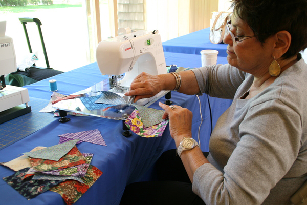  sorts fabric while Arlene Brodsky cuts it. 