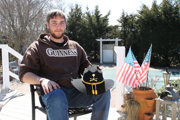 Army Specialist Andrew Kuroski holds his Cavalry hat while sitting in his parents' backyard in East Quogue on Tuesday afternoon. KYLE CAMPBELL