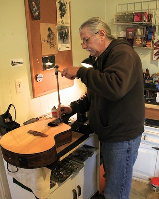 John Hanford working on an acoustic guitar in his home workshop. KYRIL BROMLEY