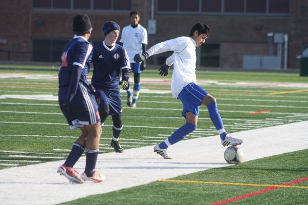 Jorge Naula (East Hampton) tries to work the ball with a pair of defenders at his back. CAILIN RILEY CAILIN RILEY