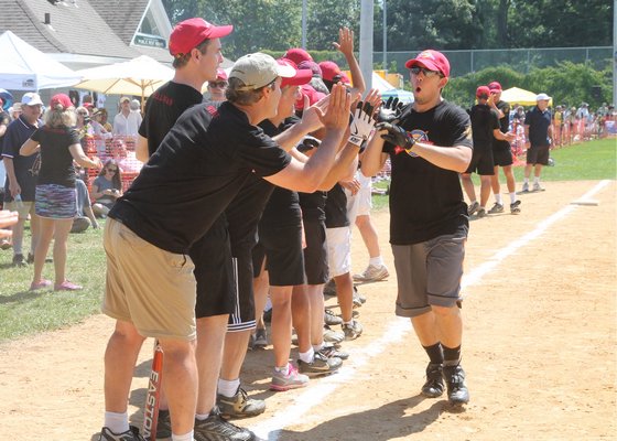 David Baer is greeted by teammates after hitting a home run. Kyril Bromley