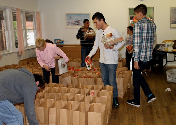 Volunteers pack bags of food for the Thanksgiving holiday at t