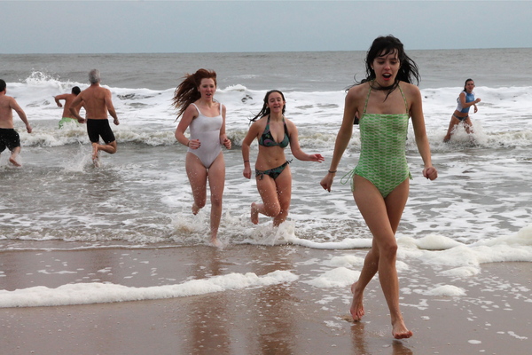 Swimmers emerge from the water after taking part in a polar bear plunge on Tuesday