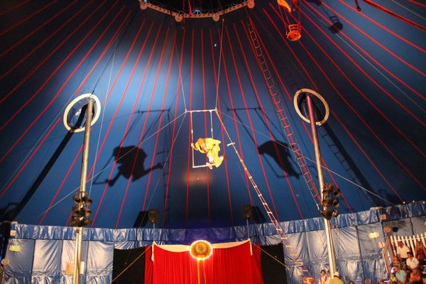 Nino the Clown takes his act up to the trapeze during a Zoppe Italian Family Circus performance Thursday night on the Great Lawn in Westhampton Beach. KYLE CAMPBELL