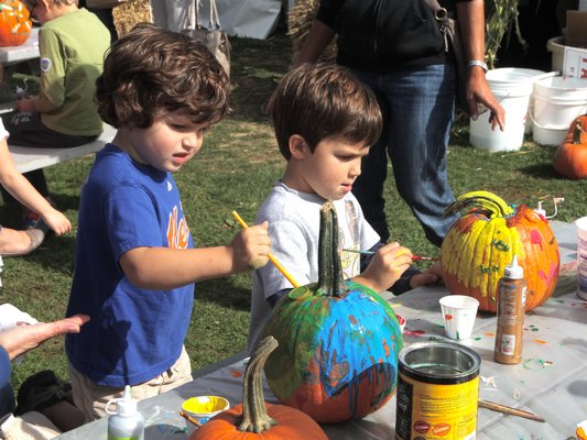 Noah and Luca Bast paint pumpkins at the Fall Festival.