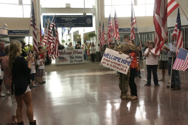 Army Specialist Andrew Kuroski is welcomed home from a nine month deployment in Afghanistan by dozens of family members Saturday afternoon in the MacArthur Airport terminal. KYLE CAMPBELL