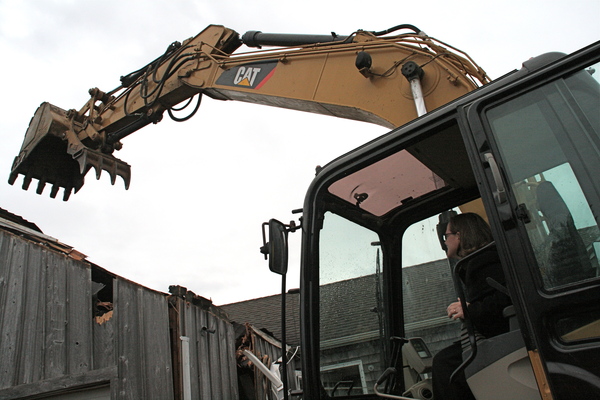 Reverend Katrina Foster delivered the first blow in the demolition of the St. Michael's Lutheran Church parsonage on Thursday. 