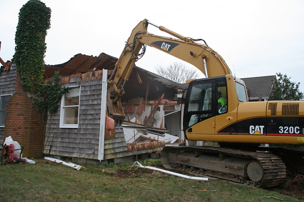 Reverend Katrina Foster delivered the first blow in the demolition of the St. Michael's Lutheran Church parsonage on Thursday. 