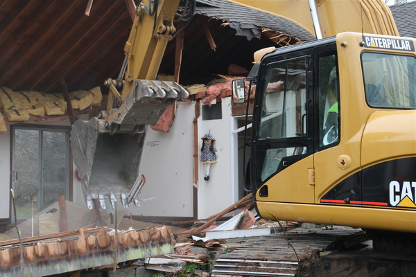 Reverend Katrina Foster delivered the first blow in the demolition of the St. Michael's Lutheran Church parsonage on Thursday. 