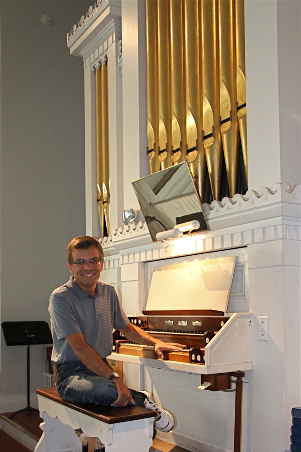 Reverend Mark Phillips with the organ at the First Presbyterian Church of Sag Harbor.