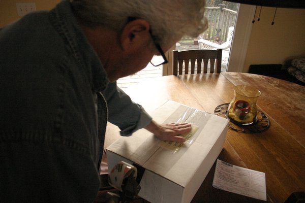 Ron Brower of East Quogue tapes up a care package for his son Kyle who is serving in the Army and will be stationed in Egypt during Thanksgiving and Christmas. KYLE CAMPBELL