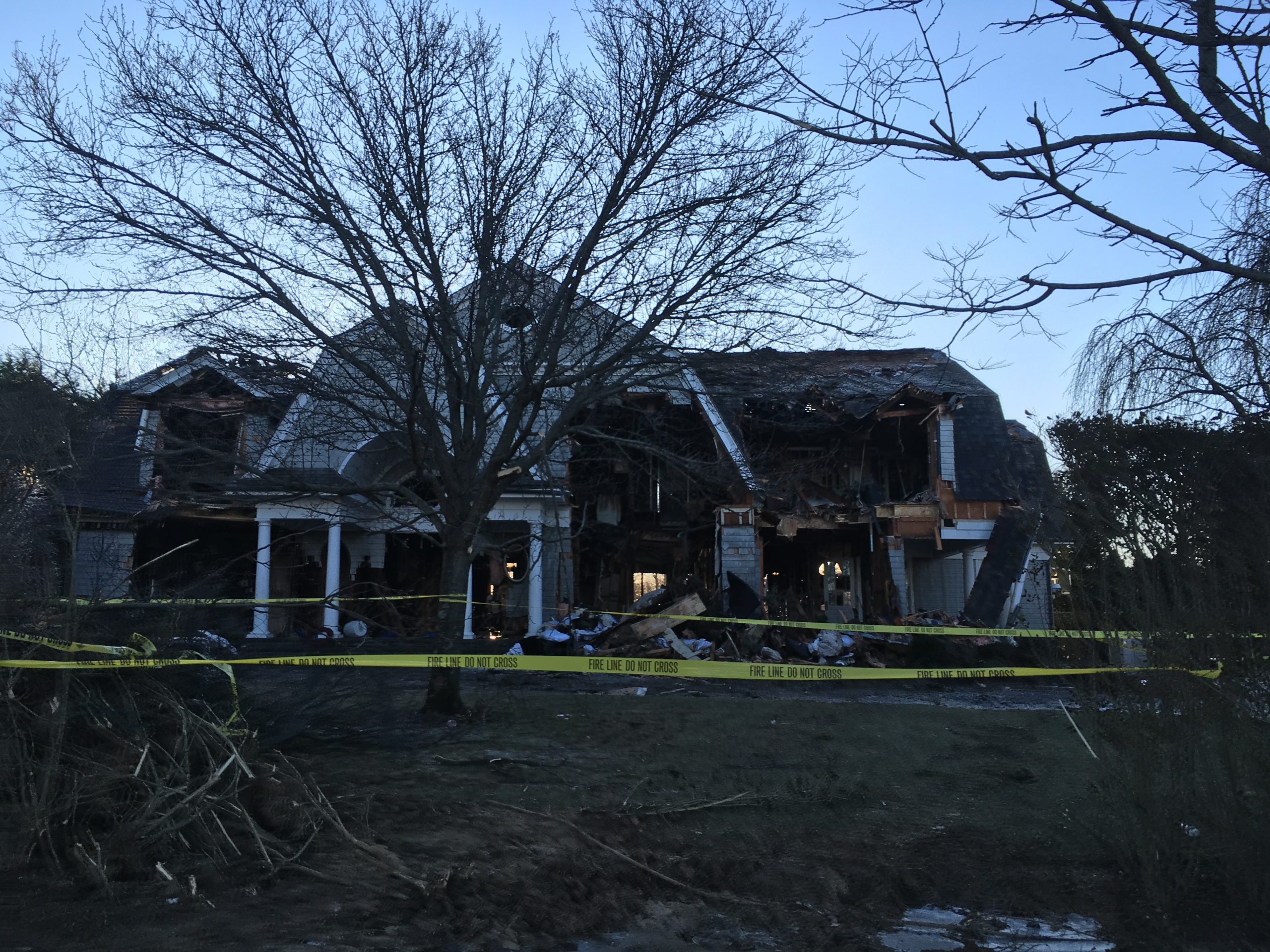 Police tape cordons off  the remains of the Bridgehampton home gutted by fire Thursday. KITTY MERRILL