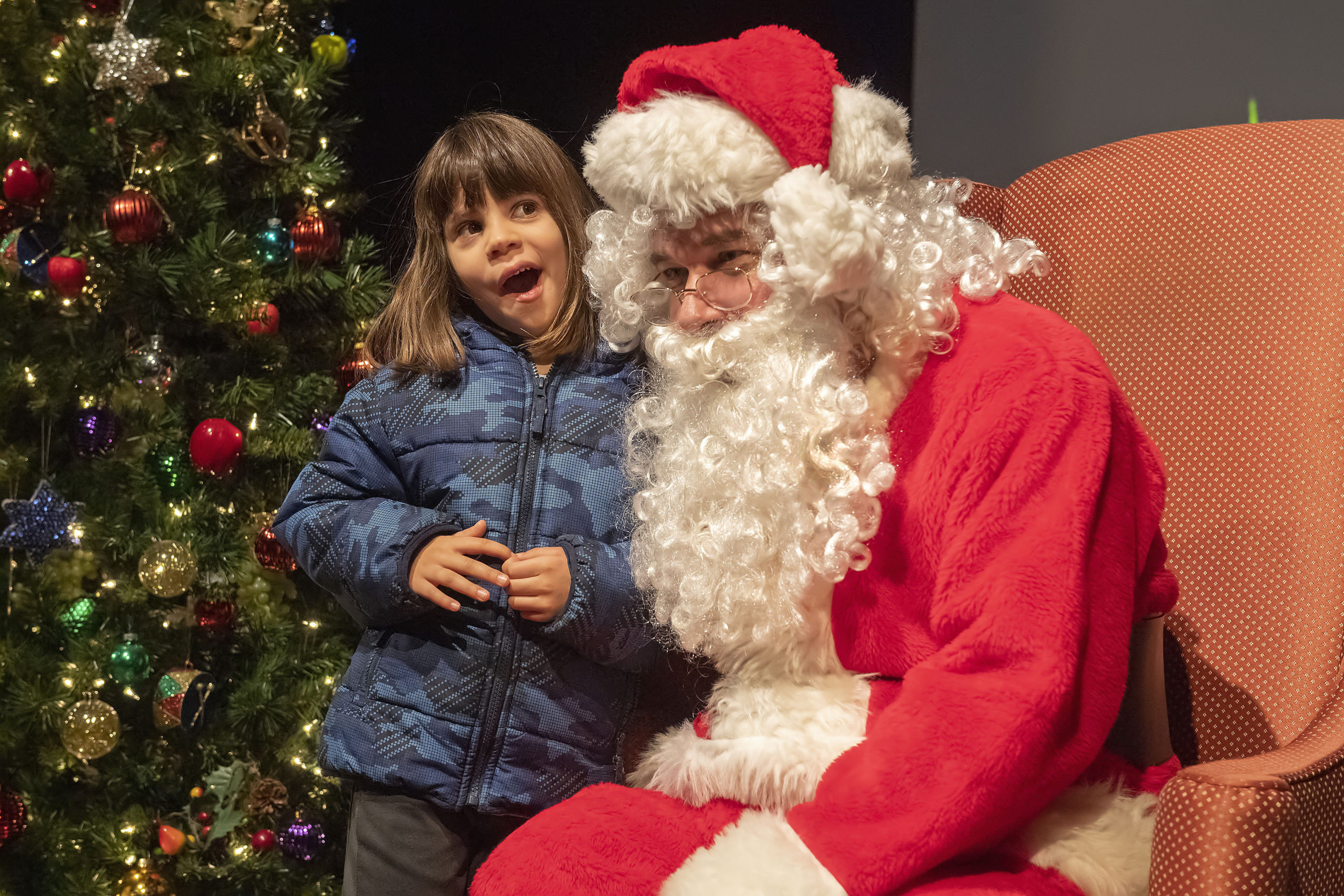 Five-year-old Carlotta Rodriguez ponders her answer anfter being asked by Santa Claus what she wants for Christmas during a Meet Santa event at the Southampton Cultural Center following the Parade of Lights, Tree-Lighting and Fireworks at Agawam Park on Saturday night.    MICHAEL HELLER