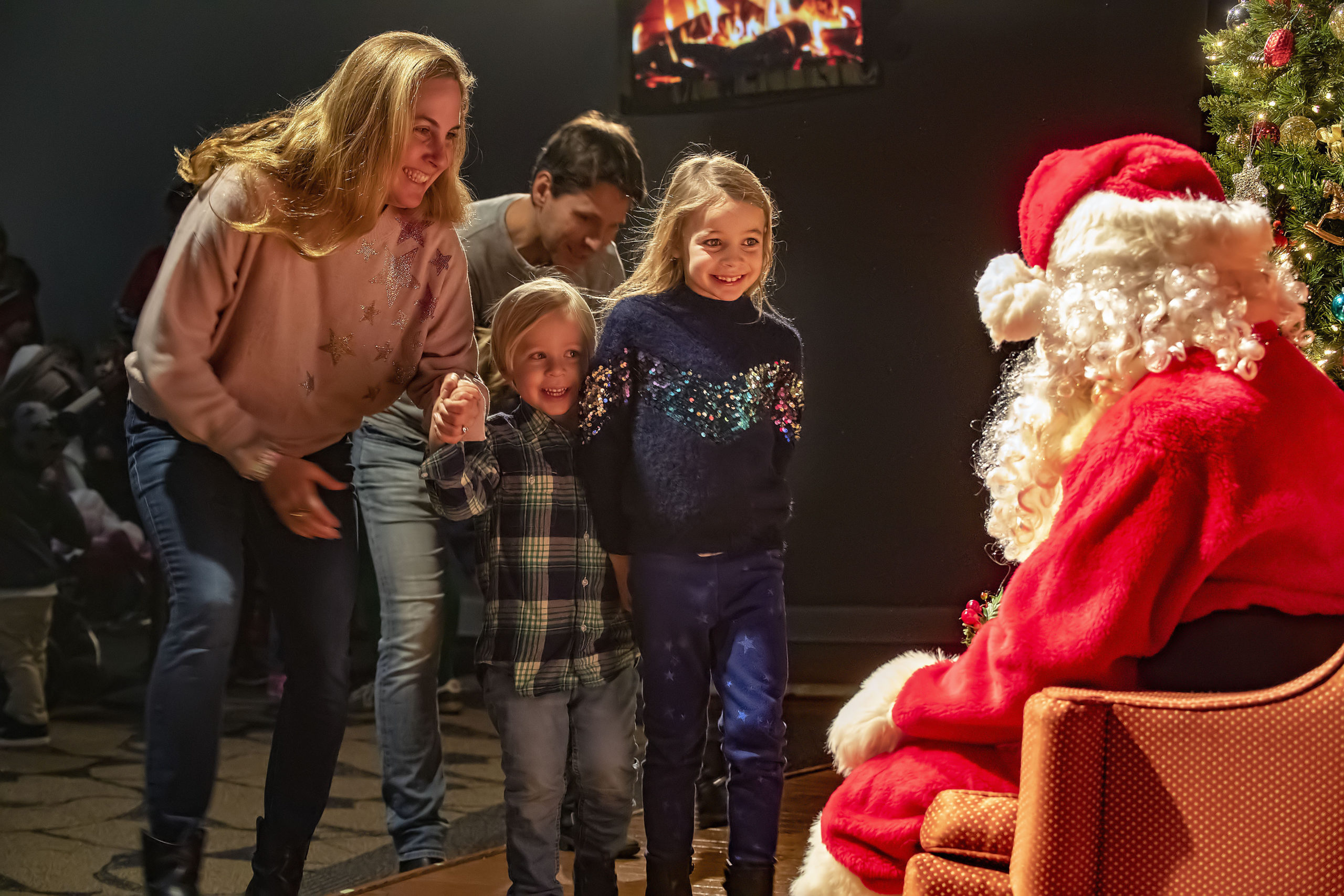 Coaxed on by mom Tessa, Heath and Isla Klepetko react to seeing Santa Claus during a Meet Santa event at the Southampton Cultural Center following the Parade of Lights, Tree-Lighting and Fireworks at Agawam Park on Saturday night.    MICHAEL HELLER