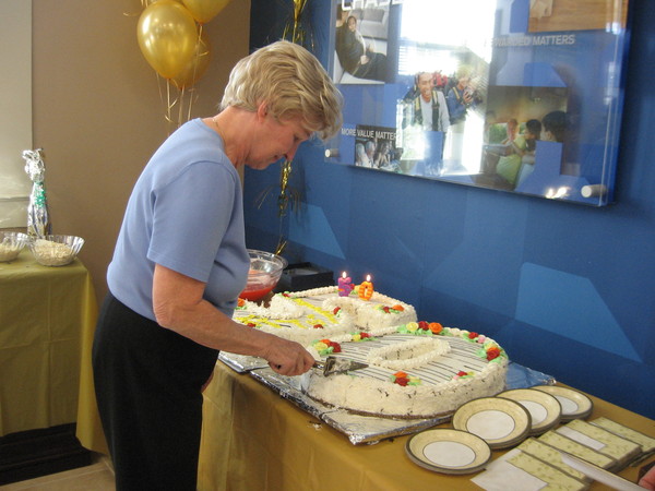 Ann Farrar cuts a cake honoring her 50 years of employment at what is now Chase bank on Main Street in Westhampton Beach. 