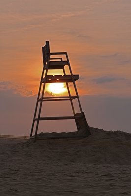 The sun slowly makes its way from behind an empty lifeguard stand at Rogers Beach in Westhampton Beach last Thursday morning. NEIL SALVAGGIO