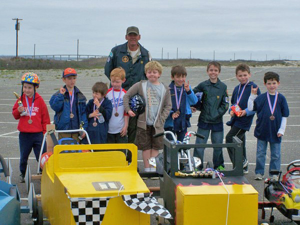 East Quogue Cub Scout Pack 261 Cubmaster Kevin Rushlo with the drivers who participated in Saturday's Soap Box Derby at Tiana Beach.