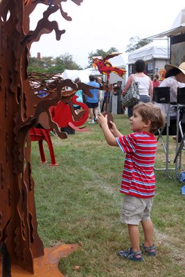  check some of Fredrick Presott's scultures at the Paragon art festival on the Great Lawn on Saturday