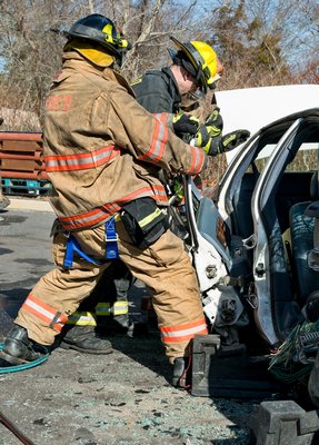 Firefighters remove a car door during Sunday's accident simulation held at the Westhampton Beach Fire Department's temporary firehouse on Sunday. COURTESY WESTHAMPTON BEACH FIRE DEPARTMENT