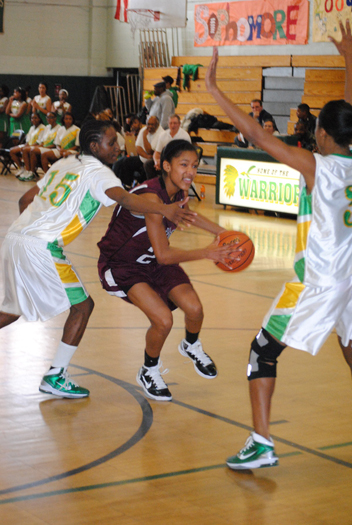 Lady Mariner Paris Hodges is stopped in her tracks by two Wyandanch players. 