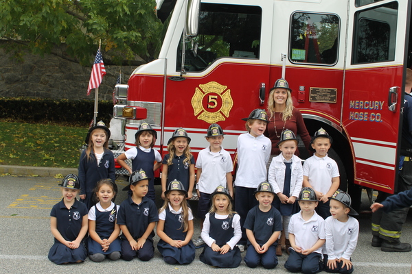 Ms. Lemanski's kindergarten class at Raynor Country Day School poses alongside the Eastport Fire Department Truck during a break in the action.
