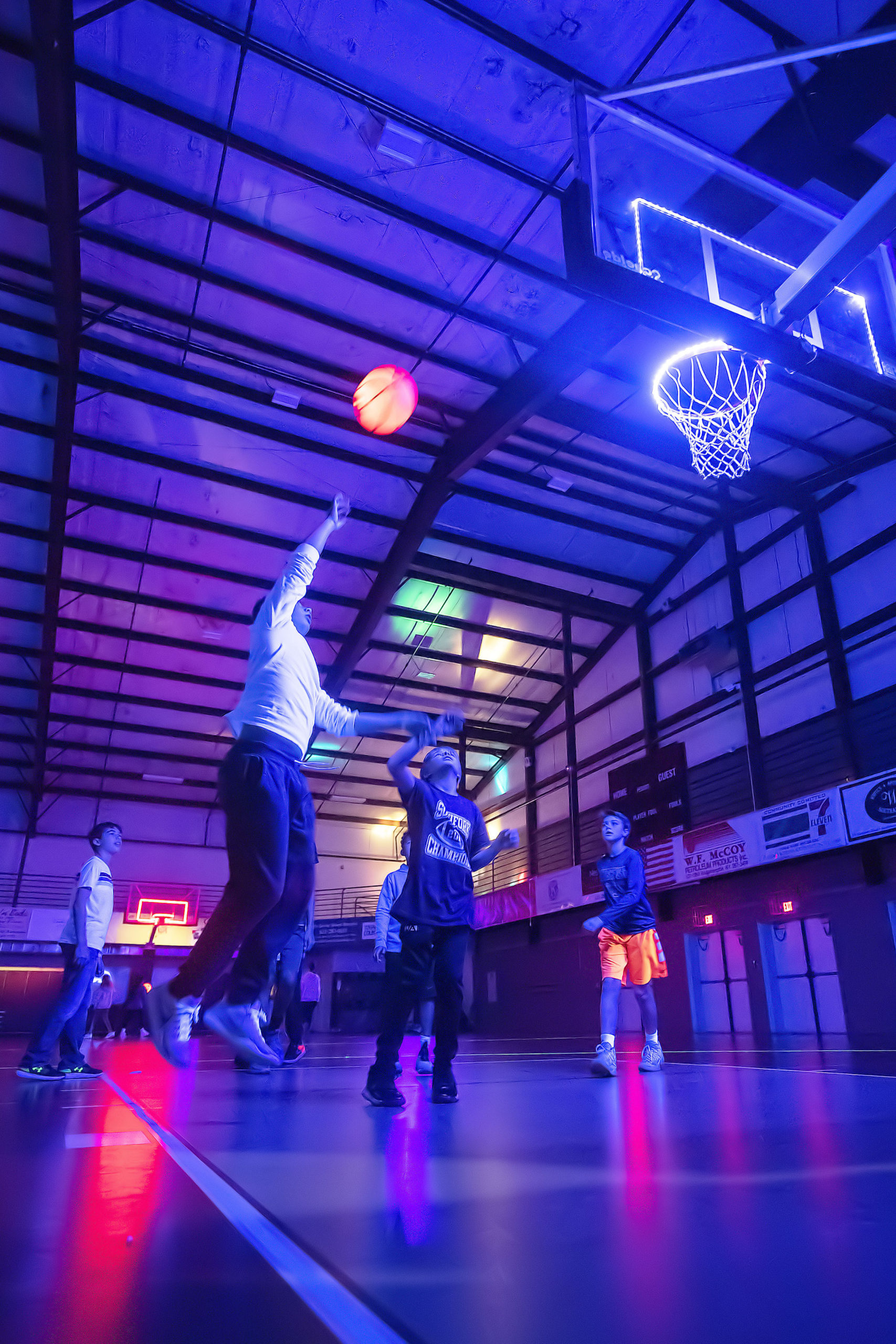 Kids shoot hoops during the Lights Out! Glow Night event at the SYS facility in Southampton on Friday night.  MICHAEL HELLER