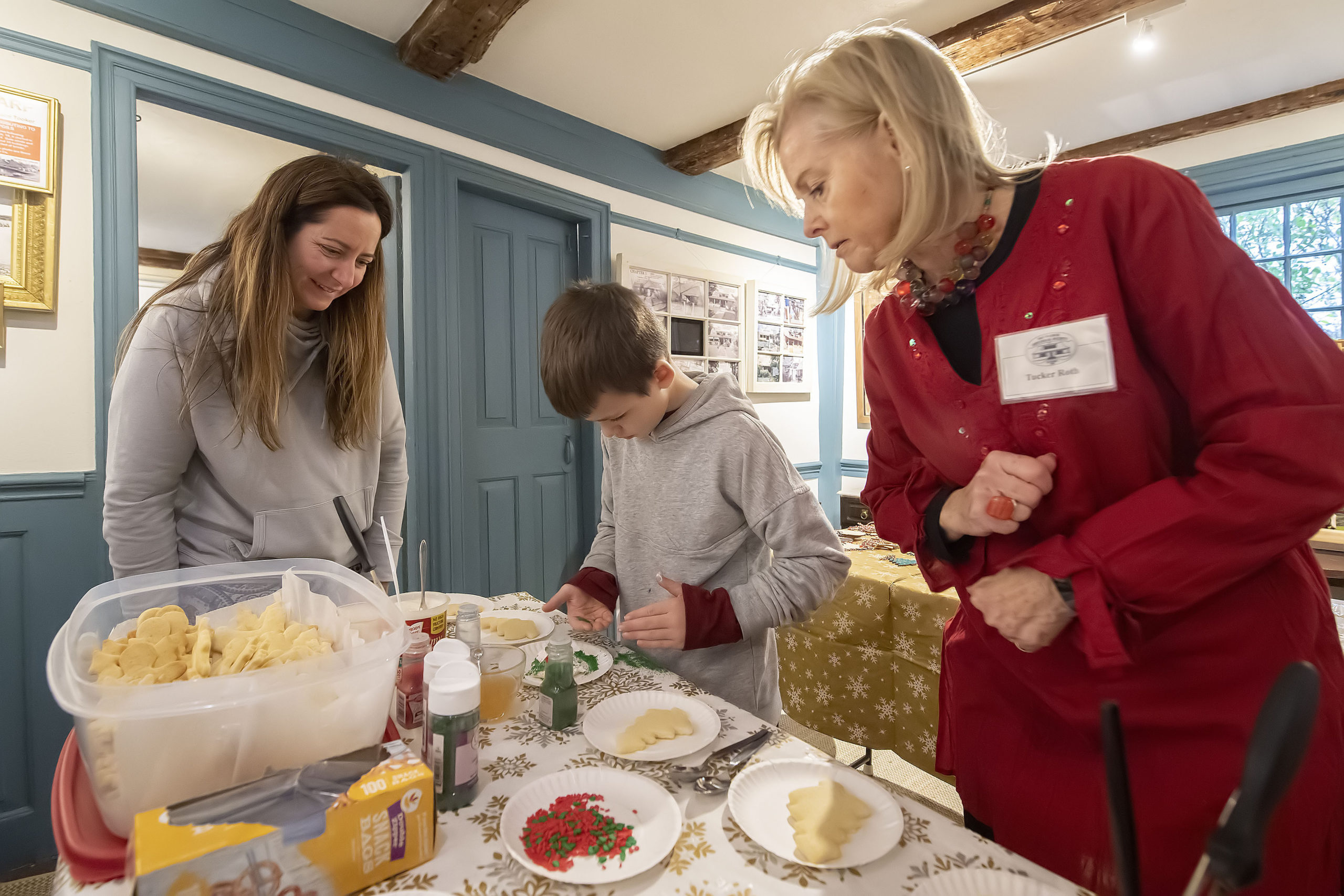 As mom Kim looks on, Tucker Roth helps Carter Garypie with decorating Christmas cookies during the annual Sag Harbor Historical Society Holiday Party at the Annie Cooper Boyd House on Sunday.    MICHAEL HELLER