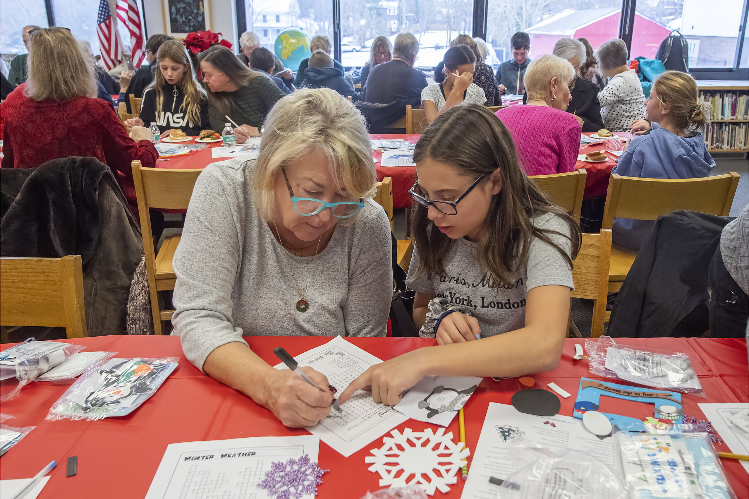 Hailey Bierfriend works on a word puzzle with her Step-Grandmother Nancy Buckley during the Pierson Middle School Snowflake Tea that was held in the Pierson High School library on Friday , December 13.     MICHAEL HELLER PHOTO