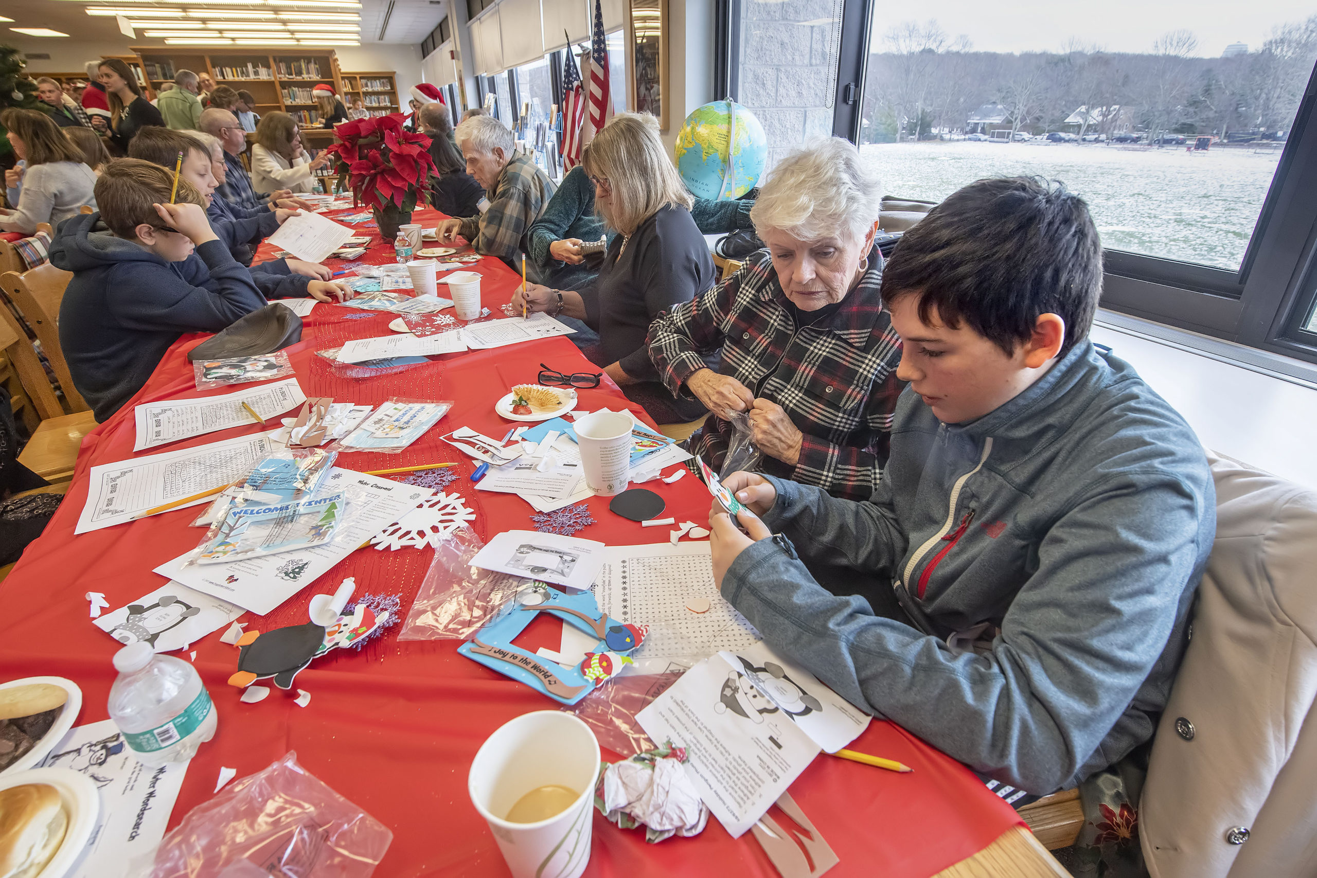 Patrick Caufield works on making a picture frame with his grandmother Gerri during the Pierson Middle School Snowflake Tea that was held in the Pierson High School library on Friday, December 13.   MICHAEL HELLER