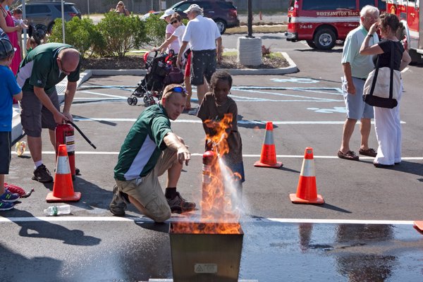 Ethan Lee douses a simulated garbage can fire at the Westhampton Beach Fire Department open house on Sunday