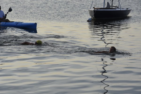 A pair of boys head towards the short following a quarter-mile swim. DREW BUDD