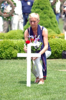 Lisa Frankenbach places flowers at services in Agawam Park on Monday.  DANA SHAW