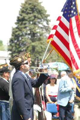 Kevin McMahon plays Taps at Memorial Day services in Southampton Village on Monday.  DANA SHAW