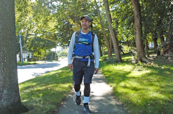 Michael Ehrlich walks through Southampton Viallge on his way to Montauk on Wednesday. DANA SHAW