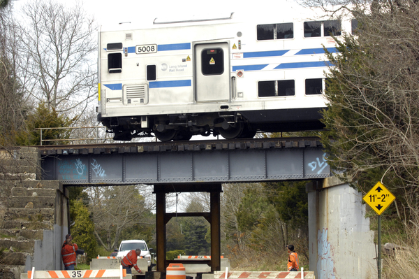 A train goes over the damaged bridge on Hill Station Road on Monday afternoon.