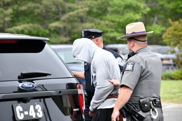 Chace Quinn is led by Southampton Town and State Police to his arraignment on Tuesday morning. DANA SHAW